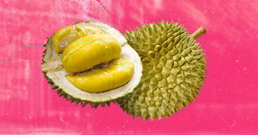 A durian, cut in half to expose the yellow fruit inside.