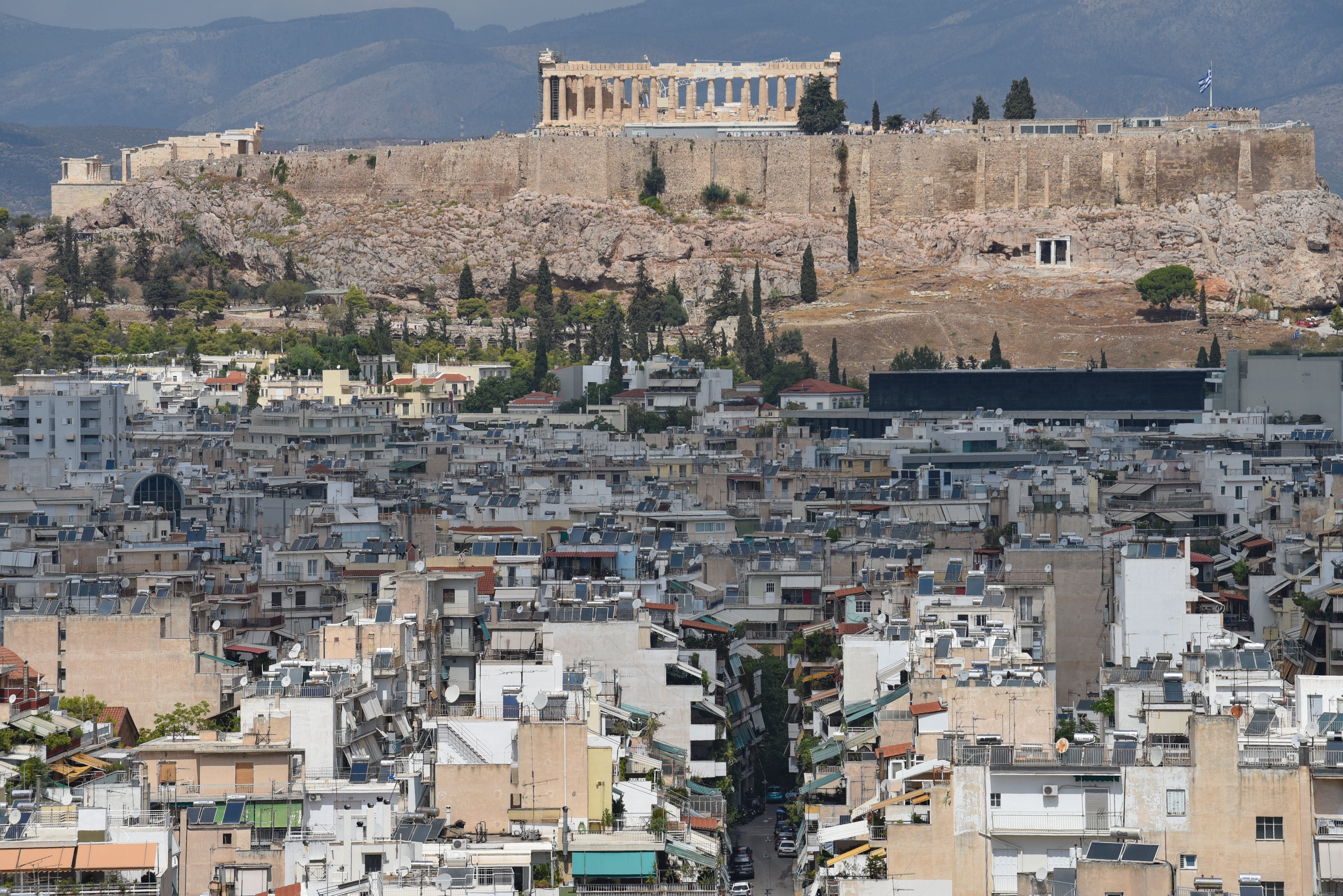Residential buildings dot the landscape of Athens below the Acropolis. (Nicolas Koutsokostas/NurPhoto via Getty Images)