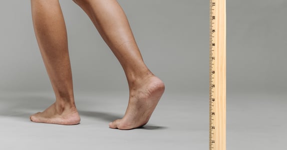 A pair of legs next to a ruler.