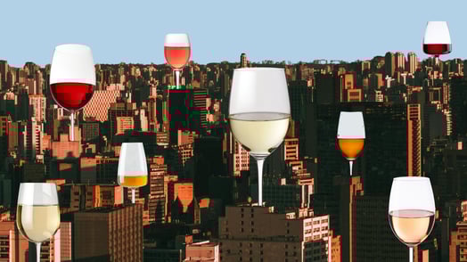 Several glasses of wine imposed over a cityscape.