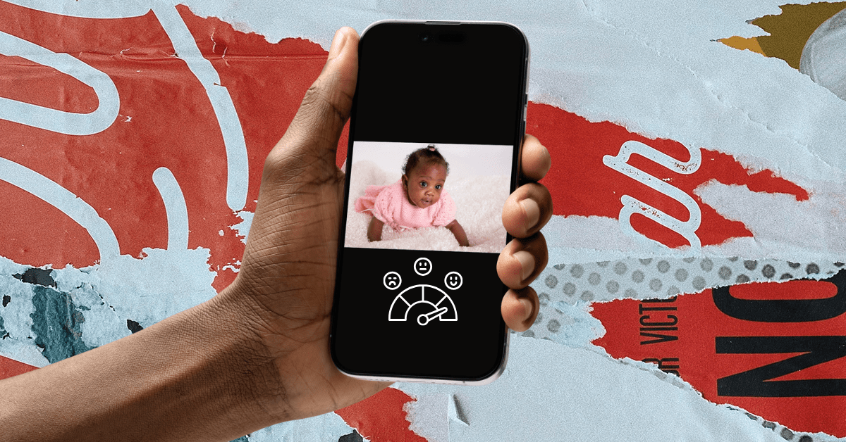  A Black arm holding a smartphone showing a Black baby crawling with a happiness scale underneath.