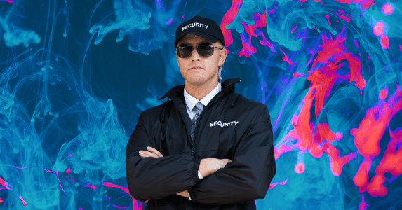 A security guard in a black jacket, hat, and sunglasses. 